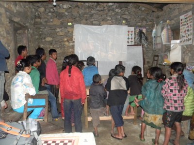 students and villagers watching the documentary on sanitation